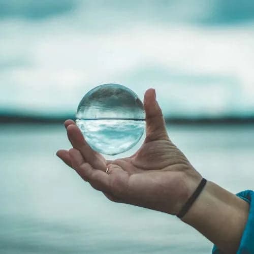 Mano sosteniendo una esfera de agua